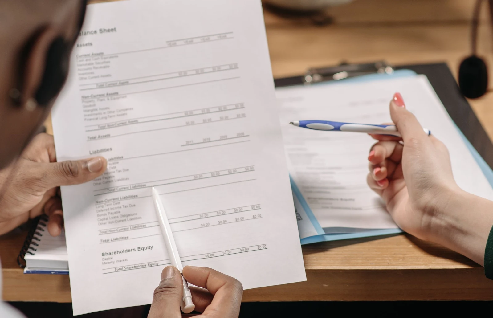 Two professionals reviewing financial documents during a negotiation