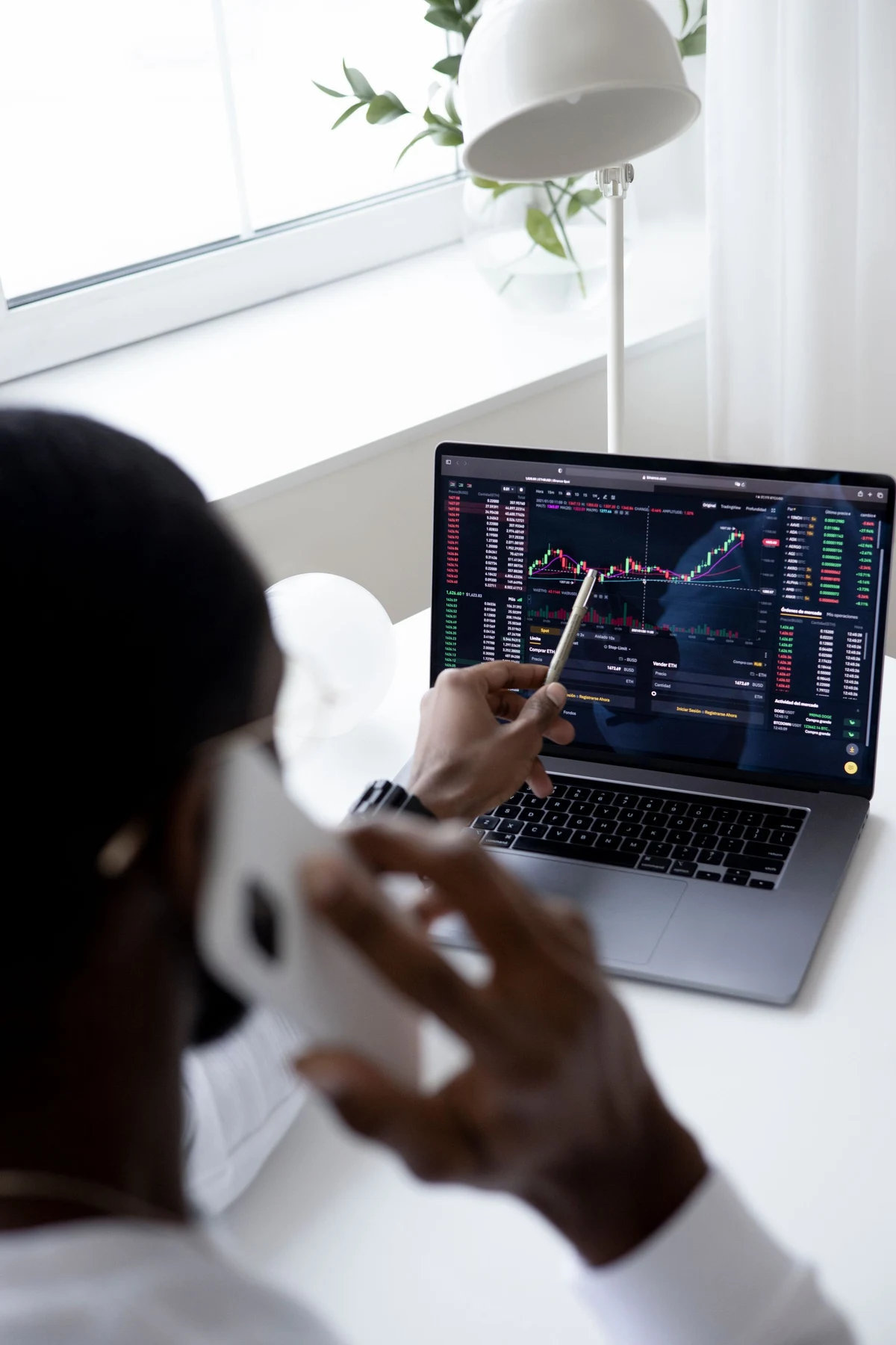 Investor analysing financial market charts on a laptop